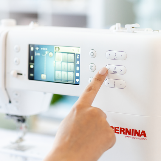 Hand bedient Seitentasten an weisser BERNINA B 335 N&auml;hmaschine, der Farb-Touchscreen zeigt Stichauswahl und Einstellungen im hellen N&auml;hraum image number