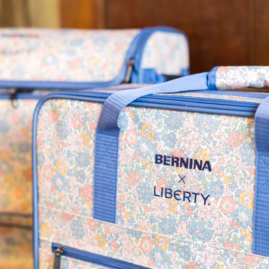 Floral BERNINA x LIBERTY soft cases with blue straps shown up close, designed for safely transporting and storing sewing machines. image number