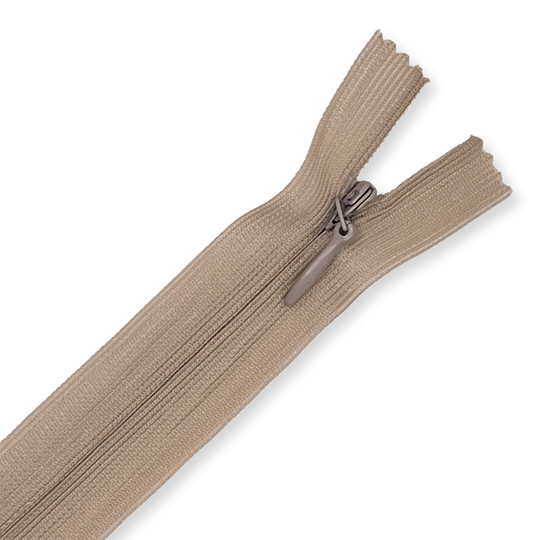 Beige closed-end zipper laid flat on a white background, showing metal slider, pull tab and evenly spaced teeth for sewing projects. image number